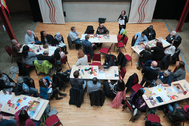 Image shows staff sitting at tables working together at the staff conference, April 2017